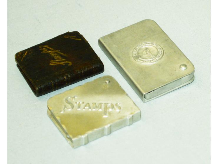 Kleines Lot mit drei Briefmarkendosen in Buchform, zwei aus Aluminium gefertigt, eine aus Bronze mit Lederüberzug. Verschiede