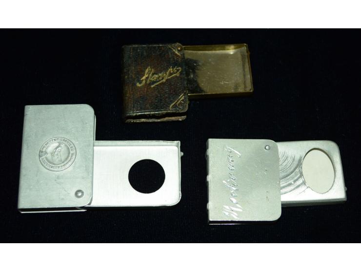 Kleines Lot mit drei Briefmarkendosen in Buchform, zwei aus Aluminium gefertigt, eine aus Bronze mit Lederüberzug. Verschiede