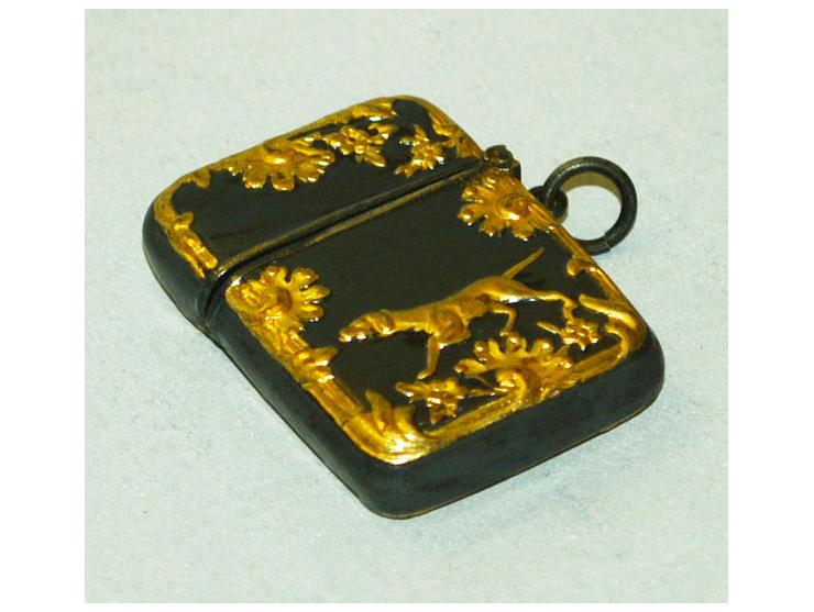 Kleine Briefmarkendose in schwarzem Metal mit erhabener und vergoldeter Jagdszene mit Hund. Die Briefmarkendose enthält ein B