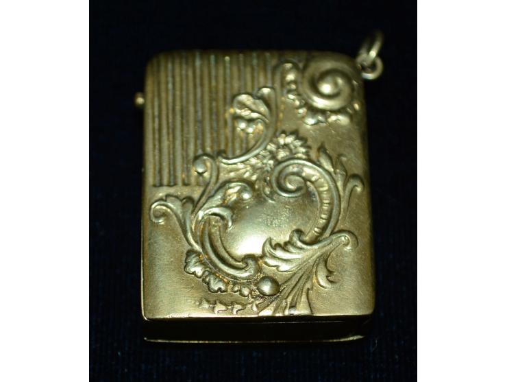 Kleine Briefmarkendose in goldfarbenem Metal, erhaben gearbeitetes Design, kleine Öse zur Nutzung als Anhänger. Gebrauchsspur