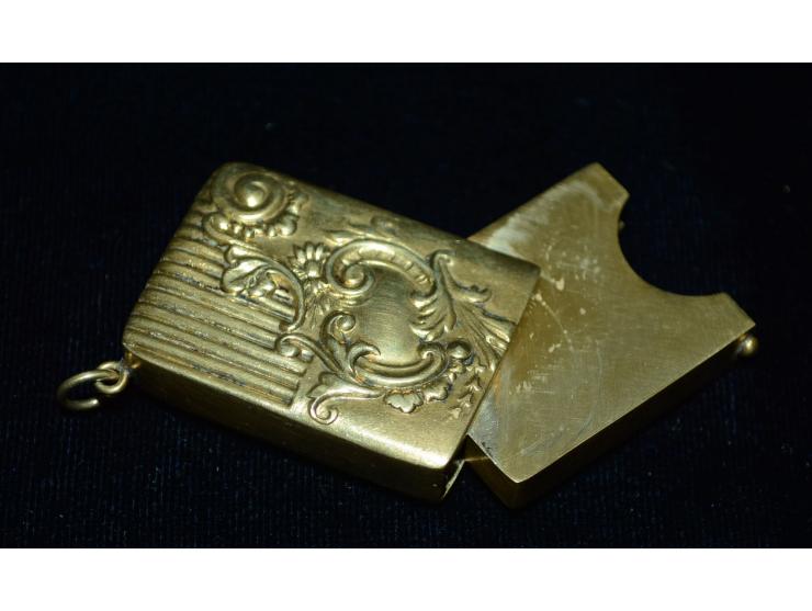 Kleine Briefmarkendose in goldfarbenem Metal, erhaben gearbeitetes Design, kleine Öse zur Nutzung als Anhänger. Gebrauchsspur