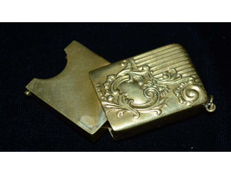Kleine Briefmarkendose in goldfarbenem Metal, erhaben gearbeitetes Design, kleine Öse zur Nutzung als Anhänger. Gebrauchsspur