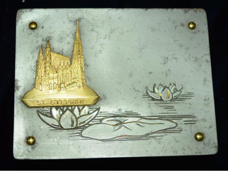 Kleine Briefmarkendose aus Bronze oder Gelbguss und grau gefärbtem Metal. Die Dose hat vier innenliegenden Briefmarkenfächer 