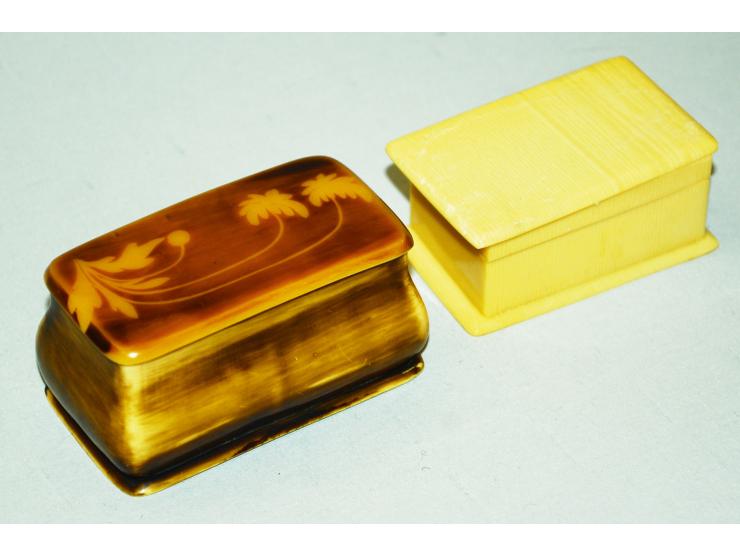Zwei ungewöhnliche Briefmarkendosen aus Bakelite. Beide Dosen haben jeweils zwei Briefmarkenfächer. Eine der Dosen weist ein 