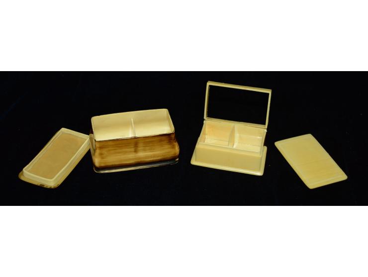 Zwei ungewöhnliche Briefmarkendosen aus Bakelite. Beide Dosen haben jeweils zwei Briefmarkenfächer. Eine der Dosen weist ein 