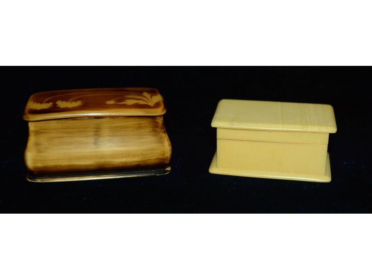 Zwei ungewöhnliche Briefmarkendosen aus Bakelite. Beide Dosen haben jeweils zwei Briefmarkenfächer. Eine der Dosen weist ein 
